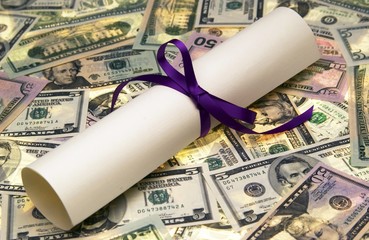 Diploma scroll tied with purple ribbon on US dollar bills.